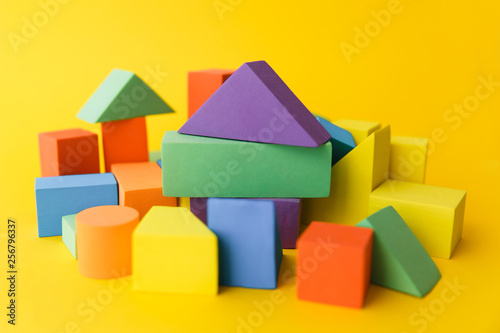 A large number of different multicoloured and different in form geometric shapes on a yellow background