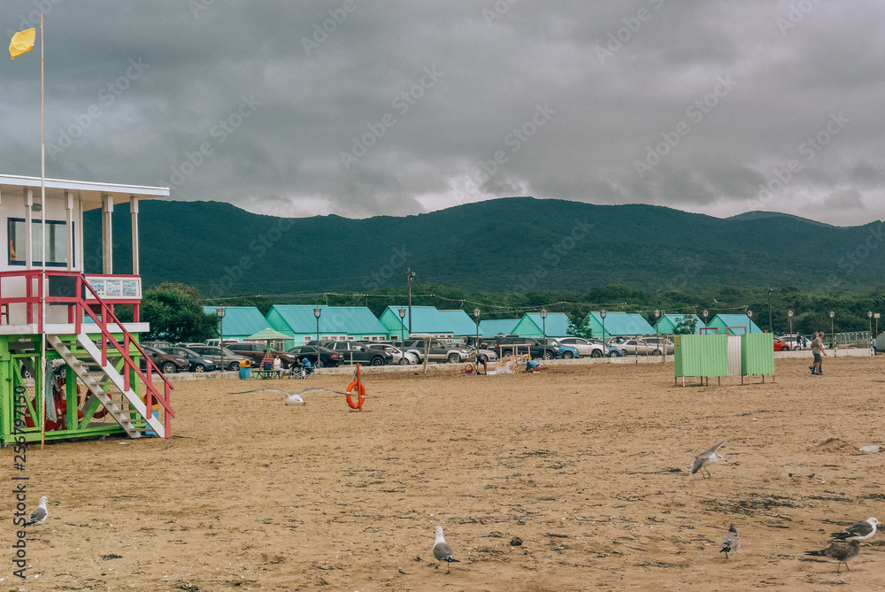 beach, wooden huts, lifeguard house, seagulls, mountains, sand beach, wooden huts, lifeguard house, seagulls, mountains, sand