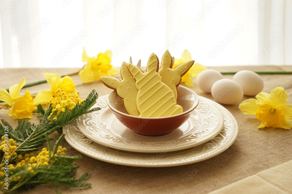 Plates with tasty Easter cookies on table