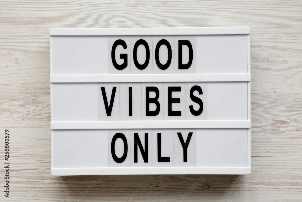 'Good vibes only' words on modern board over white wooden background, top view. From above, overhead, flat lay. 'Good vibes only' words on modern board over white wooden background, top view. From above, overhead, flat lay.