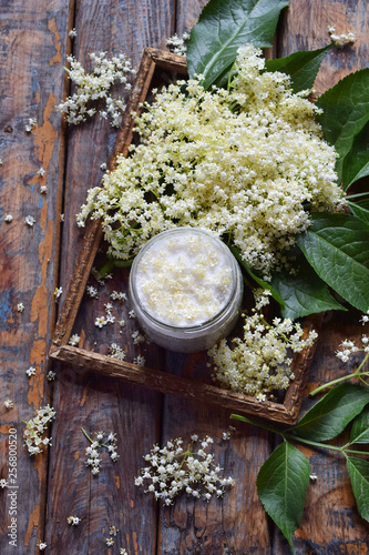 Elderflower sugar and blossom flower in wooden background. Edible elderberry flowers add flavour and aroma to drink and dessert. Copy space