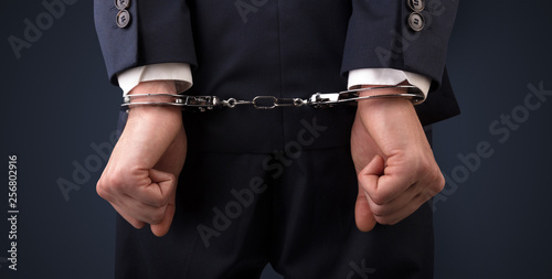 Close now arrested men hand with dark background and handcuffs

