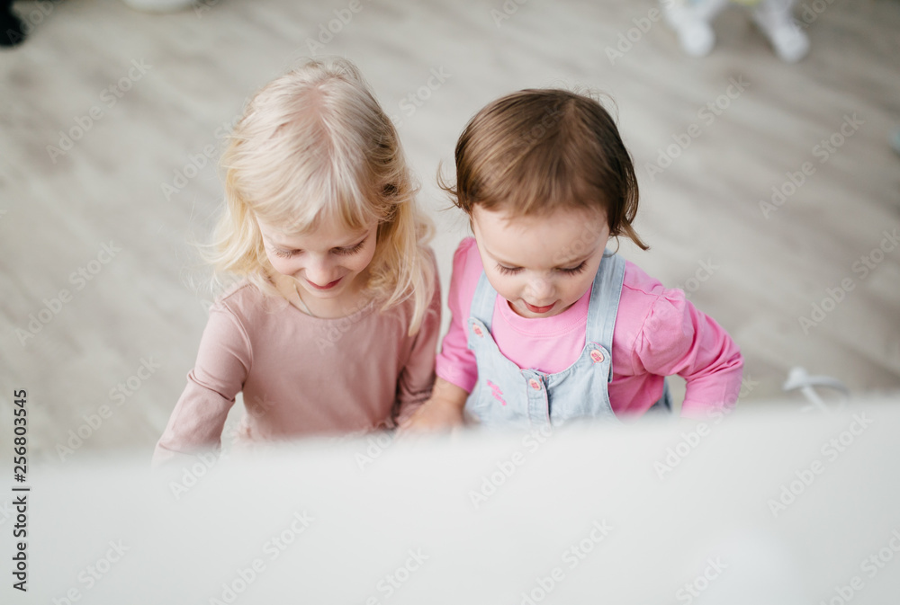 Little sisters playing in the stylish studio Little sisters playing in the stylish studio
