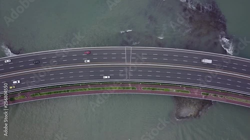 Drone aerial footage of Cars driving on a highway in Panama City over the ocean