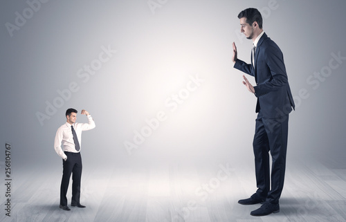 Big debutant young businessman scared of small strong businessman 