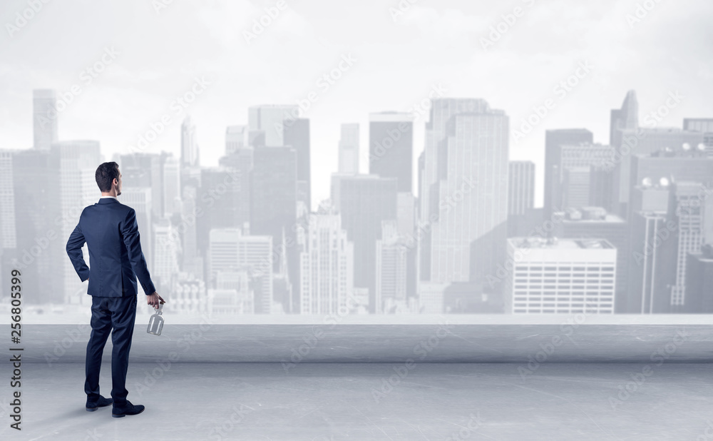 Businessman standing with his back on a roof with objects in his hand
Businessman standing with his back on a roof with objects in his hand