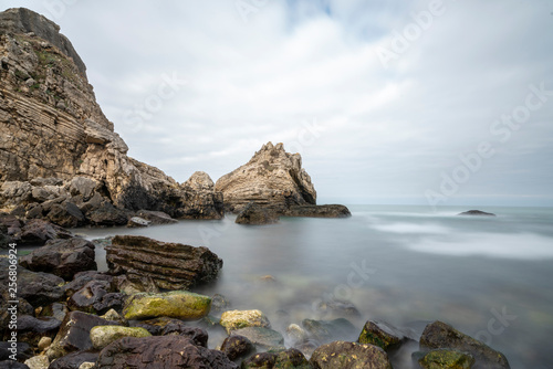 Black sea and the beach with rocks and waves with cloudy sky, 