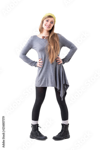 Cute innocent playful young woman with beanie in pigeon toed posture. Full body isolated on white background. 