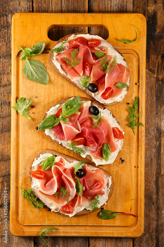 bread slice with ham, cheese and basil