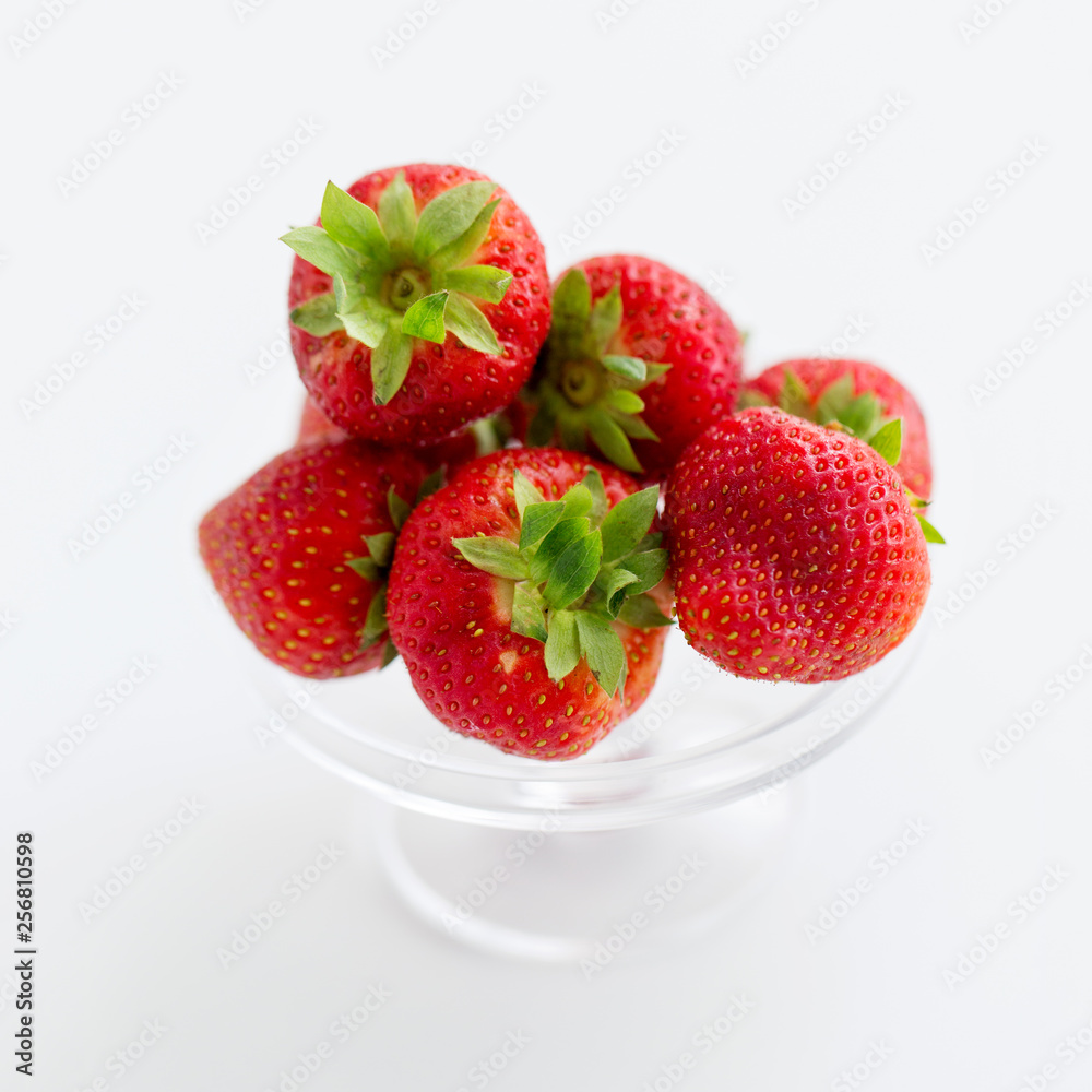 fruit, food and berries concept - strawberries on glass stand over white background fruit, food and berries concept - strawberries on glass stand over white background