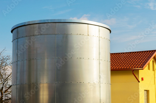 large metal tank container installed next to a house