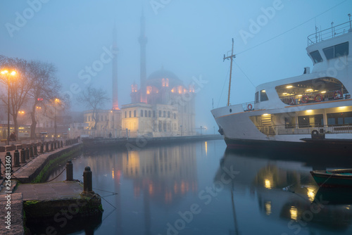Foggy day, Ortaköy Mosque and Passenger Ferry in Istanbul, Turkey.