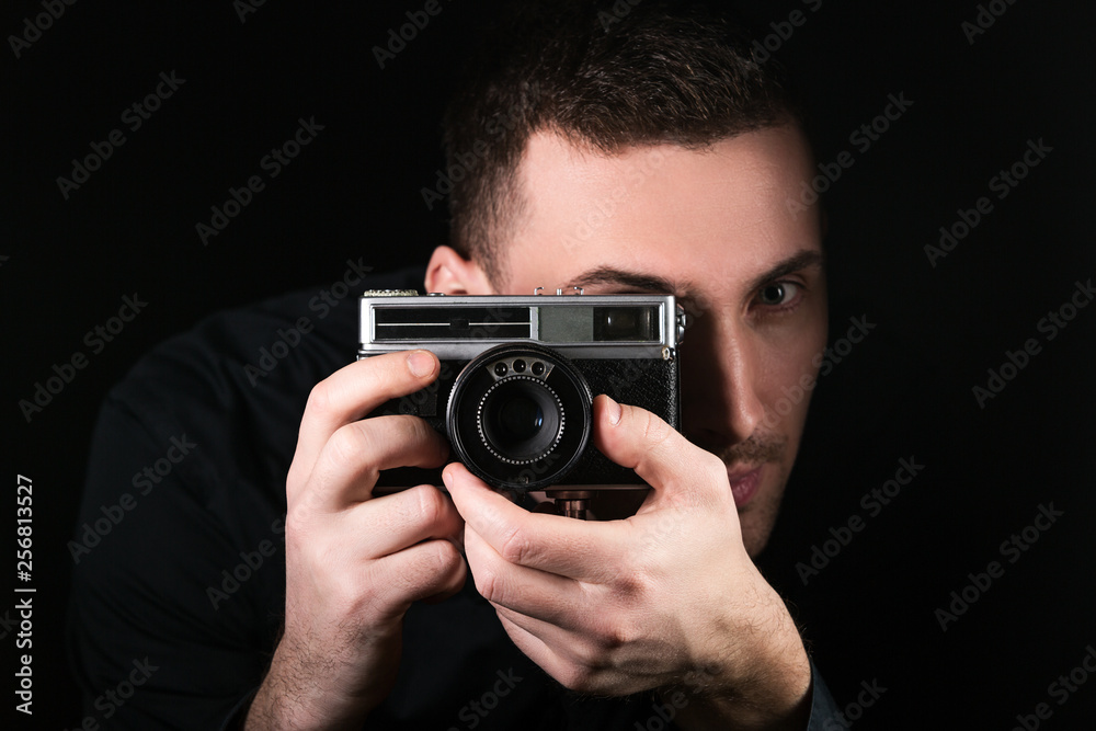 Man photographer holding a camera. Shooting process. Retro 35mm film photo camera on black background. Man photographer holding a camera. Shooting process. Retro 35mm film photo camera on black background.