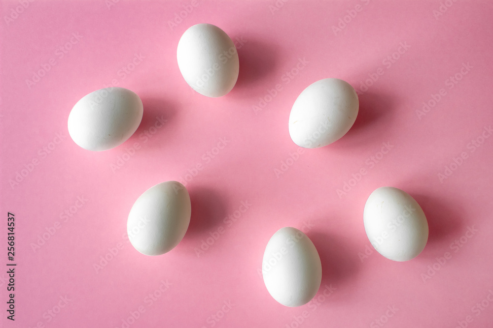 six white chicken eggs on pink background side with place for inscription