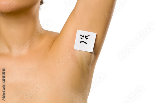 Woman shows her underarm with a angry face on her on white background