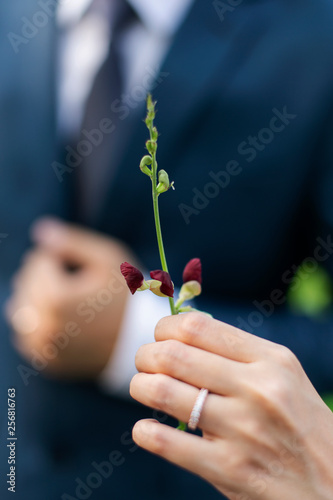 Bride holding small forest flowers bouquet. © Pornpawit