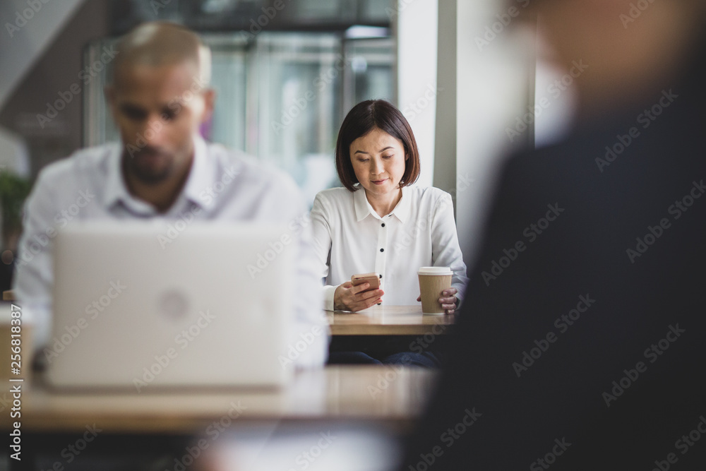 Businesswoman in a café using a smartphone Businesswoman in a café using a smartphone