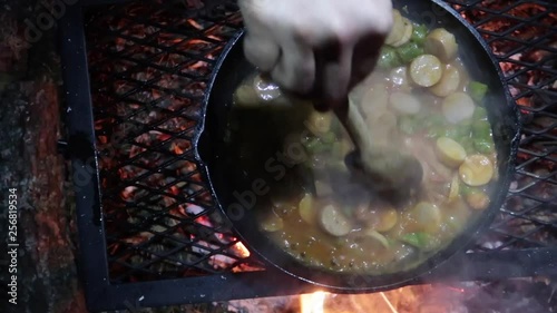Camp dinner. Preparing food on a camp fire.