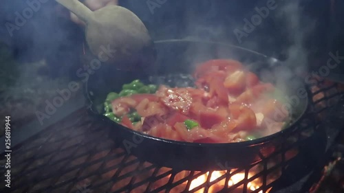 Camp dinner. Preparing food on a camp fire.
