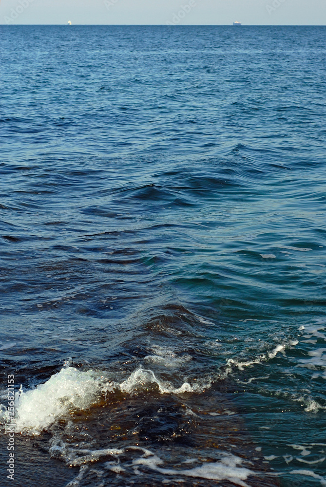 Fototapeta premium Rocky coast of the sea. Waves on the beach. Blue sea water.
