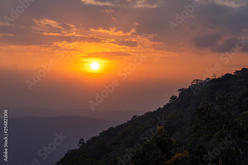 Silhouette of mountains and forest at orange sunset
