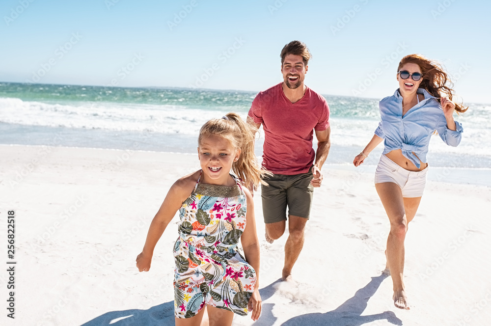 Young happy family running on beach - obrazy, fototapety, plakaty 