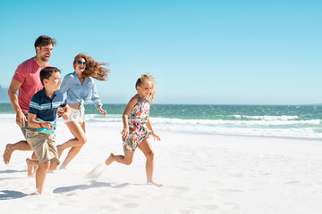Happy family running on beach