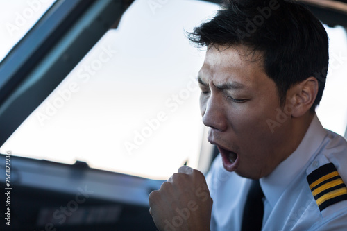 Exhausted male pilot in the cockpit airplane, flying. photo