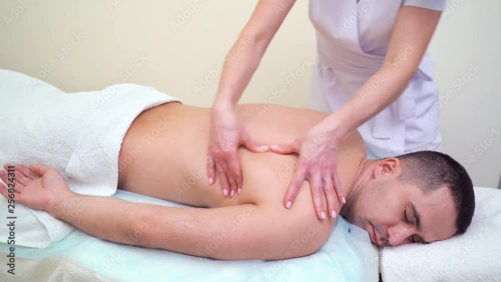 female hands massaging upper back of adult man in spa salon female hands massaging upper back of adult man in spa salon
