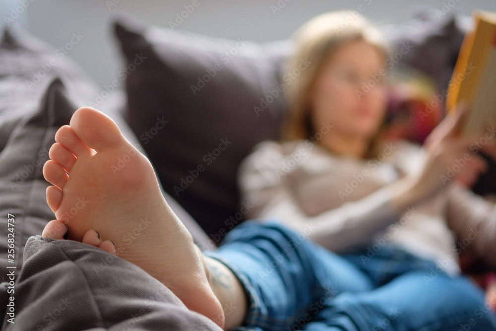 Girl reading a book at home on the couch