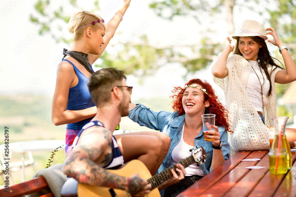 Fototapeta premium Merry curly ginger girl sing and rejoice with music guitar in hands tattooed guy