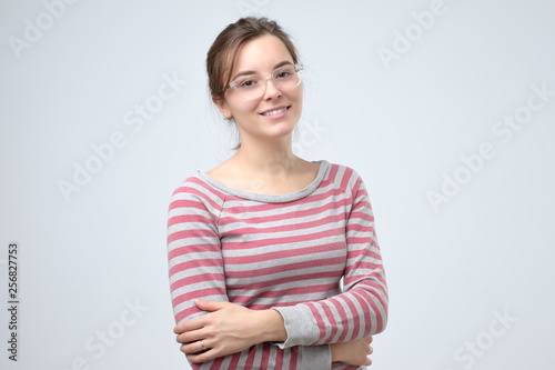 Photos Smiling young caucasian woman with her arms folded