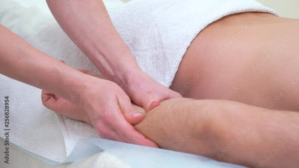 female hands massaging forearm of male customer in spa salon
