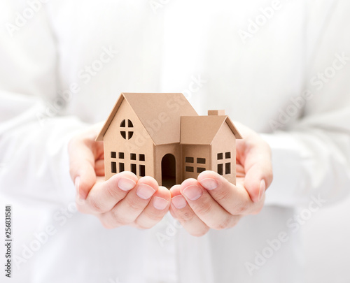 Property insurance. Cardboard house miniature in hands