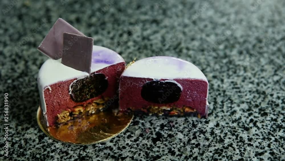 panorama of cut in half purple glazed mousse mini cake with berry jam filling served on kitchen table panorama of cut in half purple glazed mousse mini cake with berry jam filling served on kitchen table