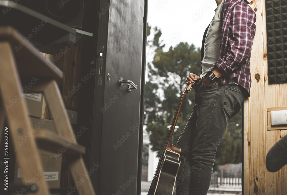 Portrait of a guy with a guitar. Musician guitarist in studio