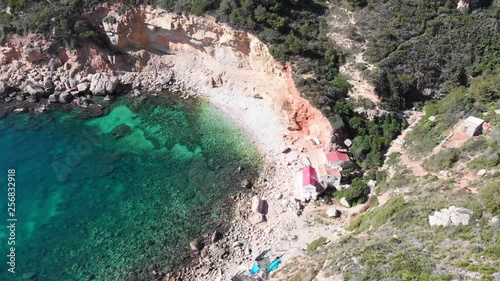 Llevant hidden cove beach in Benitatxell, Spain, with some fishermen houses photo