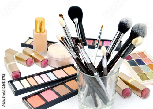 Various set of professional makeup brushes and cosmetics and palette of colourful eye shadows isolated