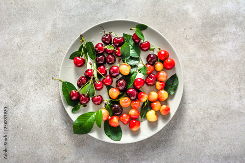 Fresh cherries on plate. Red sweet cherry fruit, flat lay, top view.