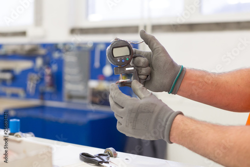 Photos Measuring thickness of the paper sheet with digital micrometer at the printing p