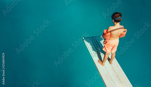 Boy standing on a diving board