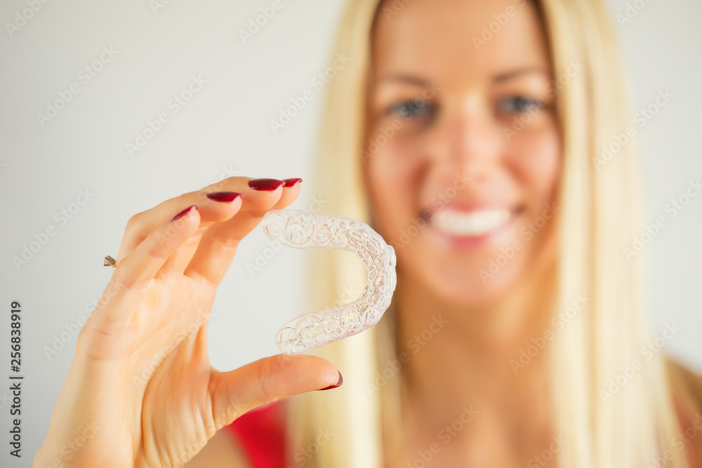 Woman with beautiful smile holding teeth whitening tray - obrazy, fototapety, plakaty 