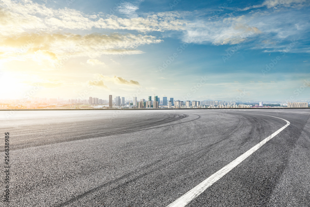 Fototapeta premium Asfaltowy tor wyścigowy i nowoczesna panorama miasta z budynkami w Szanghaju