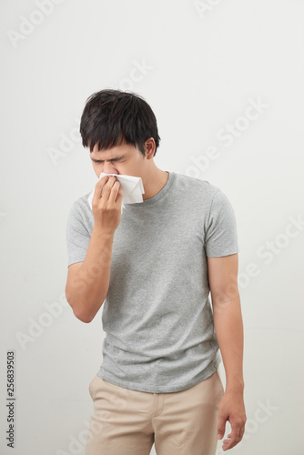 man is sick and sneezing with white background, asian