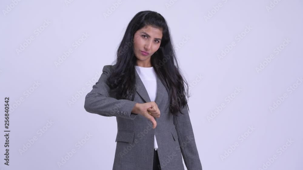 Young angry Persian businesswoman giving thumbs down Young angry Persian businesswoman giving thumbs down