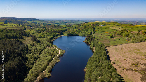 cod beck reservoir in north yorksire showing the blue waters and trees around the lake