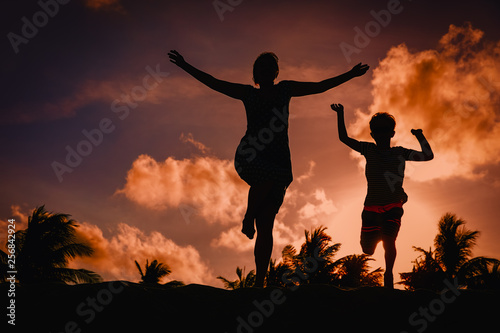 mother and son play at sunset, family enjoy tropical vacation