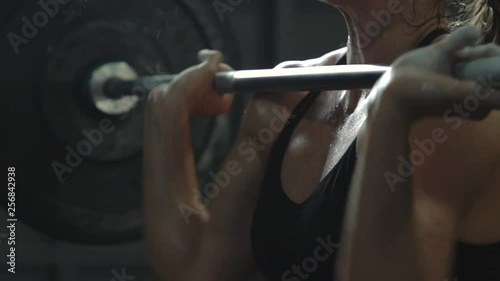 crossfit girl athlete doing exercise with a barbell. power cleans front squats slow motion