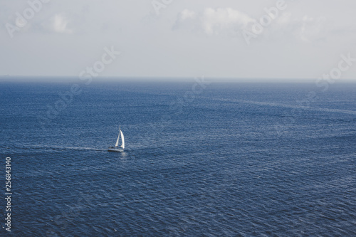 tourism cruise vacation travel concept photography of lonely yacht on calm water surface in open sea natural scenic environment, simple landscape pattern with empty copy space