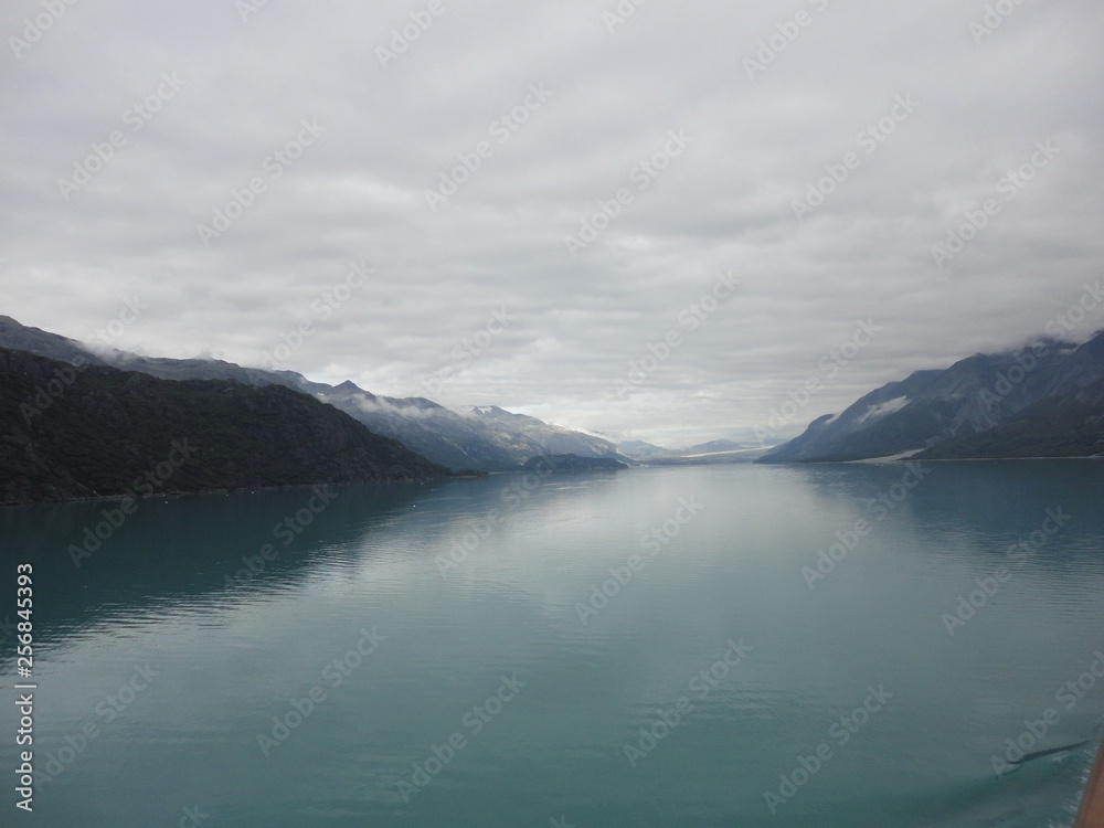 Pacific Ocean fading off to the Horizon between rolling mountains with a cloudy sky